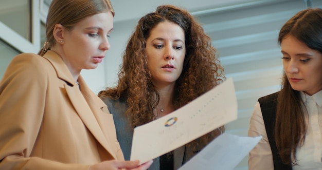 Toma un primer plano medio de un grupo de trabajo ocupado de tres mujeres que encuentran soluciones