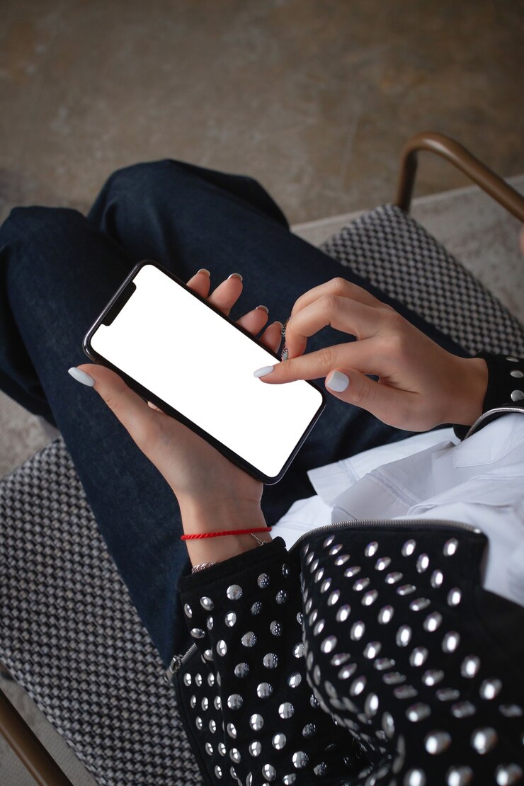 Toma de primer plano de una mujer escribiendo en un teléfono celular. Mano de niña sosteniendo un teléfono inteligente moderno y apuntando a la pantalla. Pantalla en blanco, página web propia o mensaje, aislado en un fondo blanco