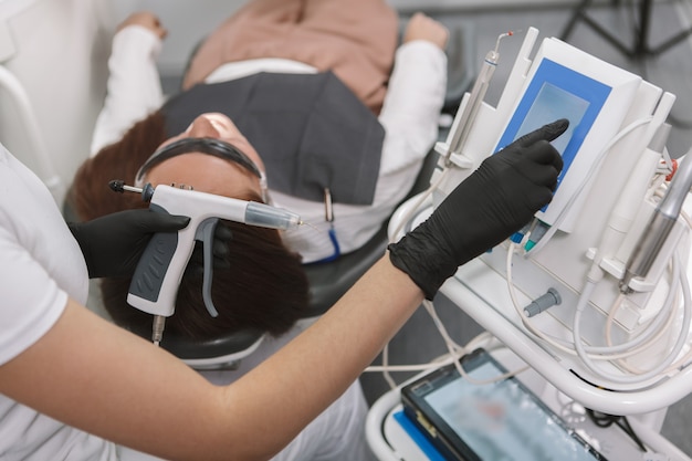 Toma recortada de un dentista con equipo dental automatizado en su clínica