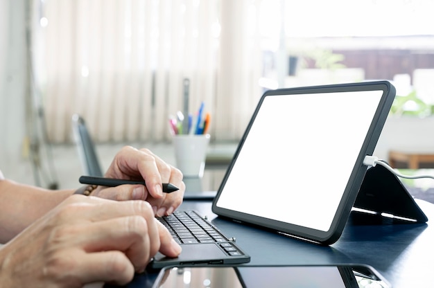 Toma recortada de la mano del hombre con tableta y teclado, maqueta de pantalla en blanco para diseño gráfico o exhibición de productos.