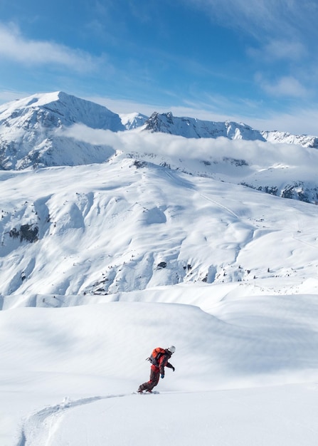 Foto una toma vertical de un hombre haciendo snowboard en montañas nevadas