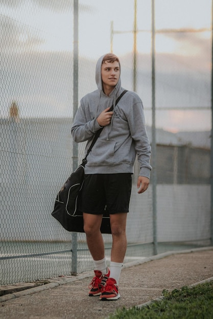 Toma vertical de un jugador caminando con ropa de entrenamiento.