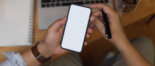 Toma de vista superior de la mano que sostiene el teléfono inteligente