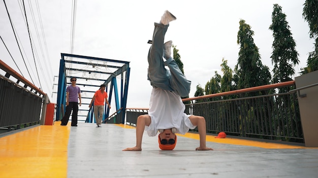 Foto tomada panorámica de un hipster realizando una actuación de bboy y dando pasos enérgicos