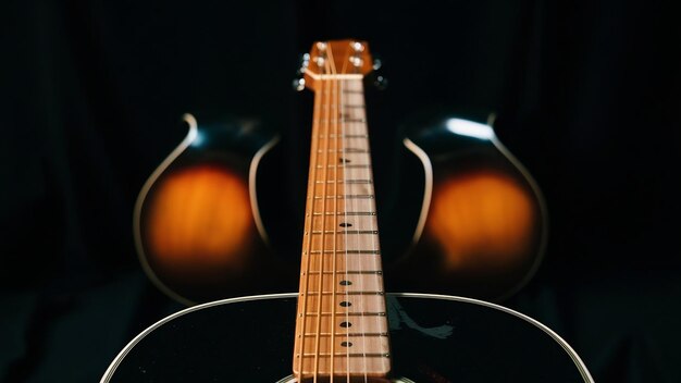 Tomada de primer plano del fretboard de una guitarra acústica aislada en negro