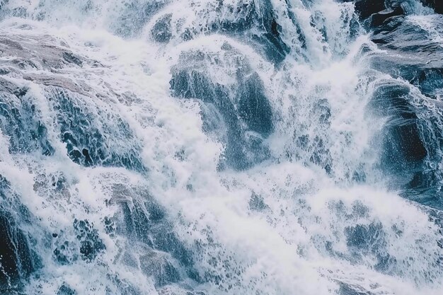 Tomada vertical de un camino que conduce a una cascada bajo un cielo nublado azul