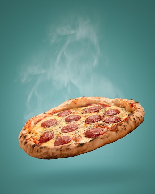Tomada vertical de una deliciosa pizza con salami pepperoni sobre un fondo azul
