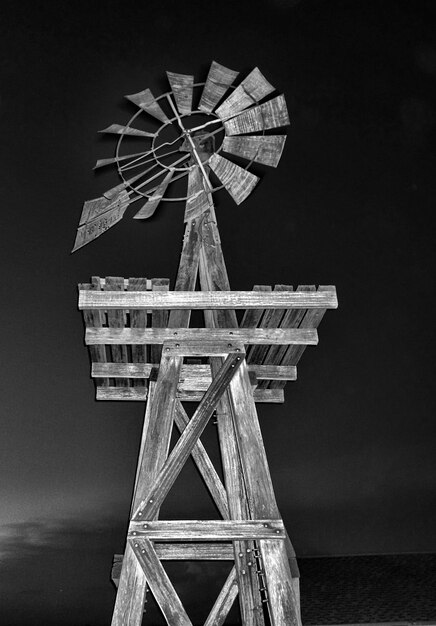 Foto tomada vertical de un molino de viento de casa de madera por la noche