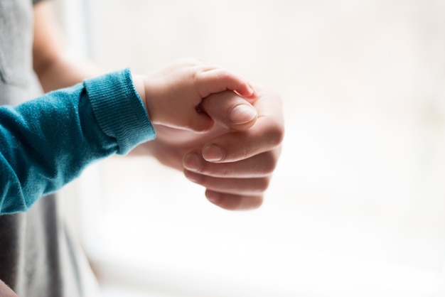 Tomados de la mano. Dale al bebé durmiendo en la mano del padre primer plano. manos aisladas sobre fondo blanco