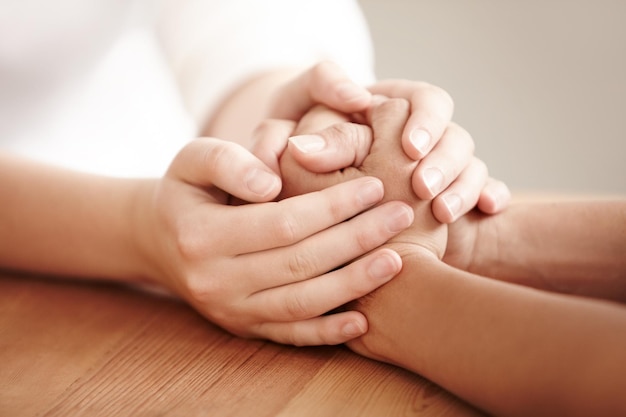 Tomados de la mano entrenador de vida y personas con cuidado y comunidad mostrando empatía y amor con amabilidad Consuelo esperanza y una persona que da la mano para la confianza en la salud mental y el perdón juntos