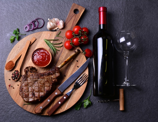 Tomahawk Steak mit Gewürzen und Gemüse, Wein