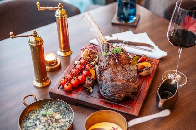 Tomahawk Steak mit Kartoffelpüree, gebackenem Spinatkäse und Bratensauce.