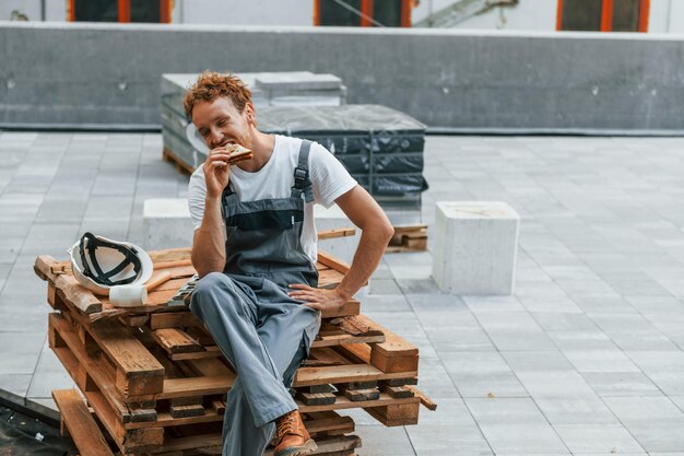 Tomando un descanso Joven trabajando en uniforme en la construcción durante el día