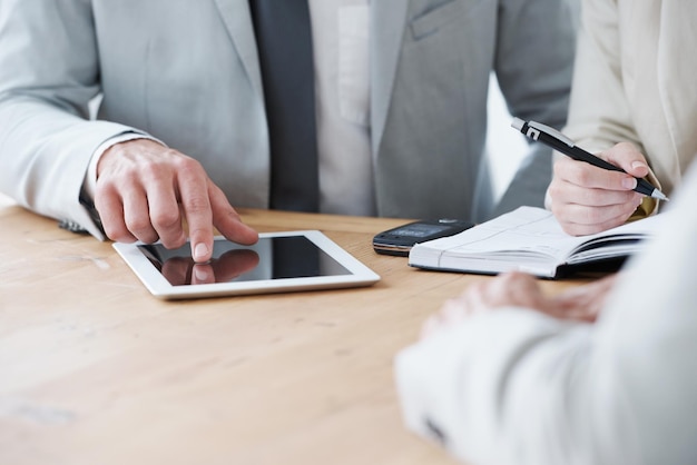 Tomando notas en su tableta digital Captura recortada de un hombre de negocios usando una tableta digital durante una reunión
