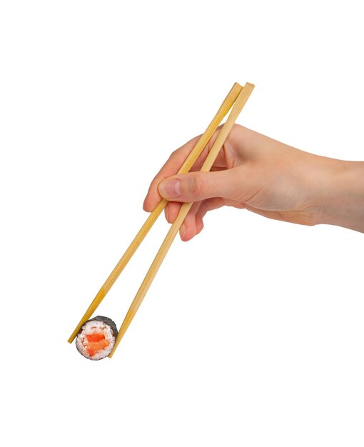 Foto tomando un rollo de maki de salmón con palillos en la mano aislados sobre un fondo blanco