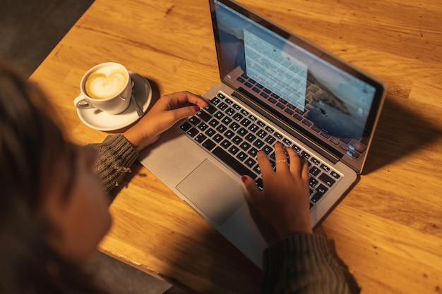 Tomando um café falando ao telefone e trabalhando no computador