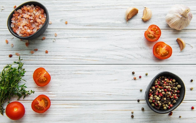 Tomate, albahaca y pimiento con ajo sobre superficie de madera blanca