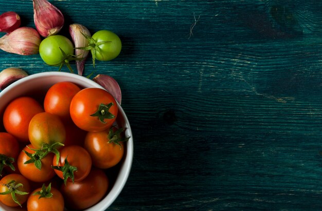 Tomate, alho em uma superfície de madeira.