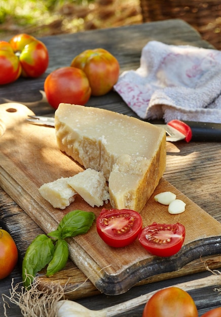 Tomate alho manjericão e queijo parmigiano em uma velha mesa autêntica