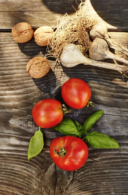 Tomate, alho, manjericão em uma velha mesa autêntica. Ingredientes caseiros frescos para massas