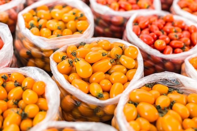 Tomate amarelo e vermelho em saco de plástico