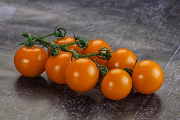 Tomate amarillo dulce en la rama