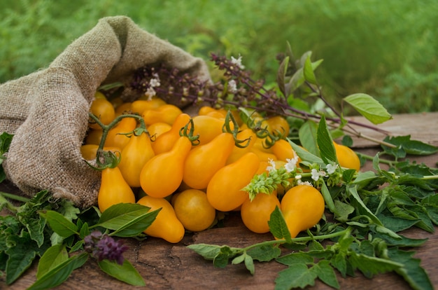 Tomate amarillo en forma de pera en una mesa de madera