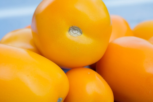 Tomate amarillo en mesa azul