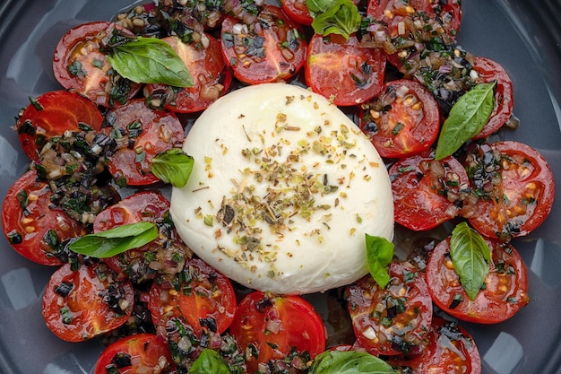 Tomate assado com queijo mussarela em um fundo de madeira