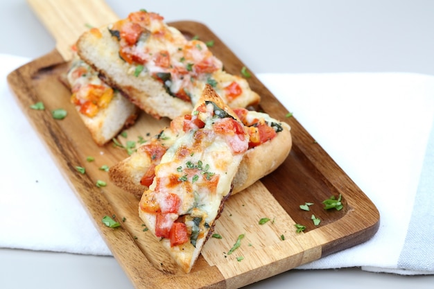 Tomate bruschetta servindo em prato de madeira.