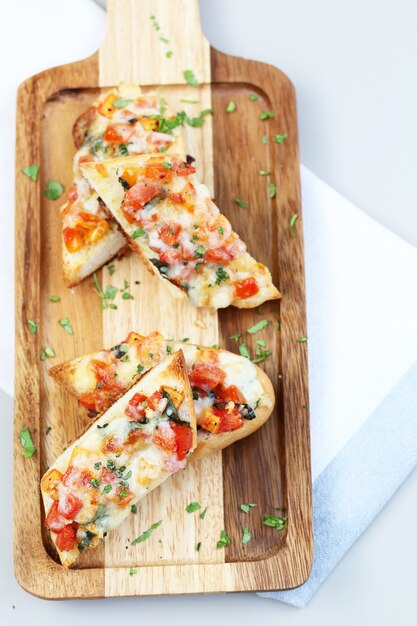 Tomate Bruschetta sirviendo en la placa de madera.