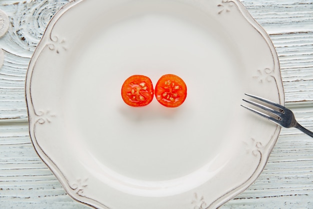 tomate cereja cortado aberto em chapa branca minimalista