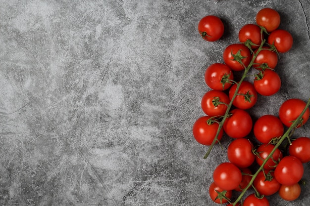 Foto tomate cereja de cluster sobre o pano de fundo cinzento