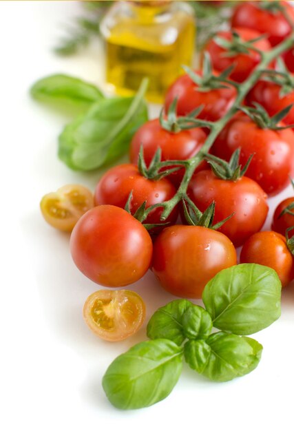 Tomate cereja e manjericão isolado no branco