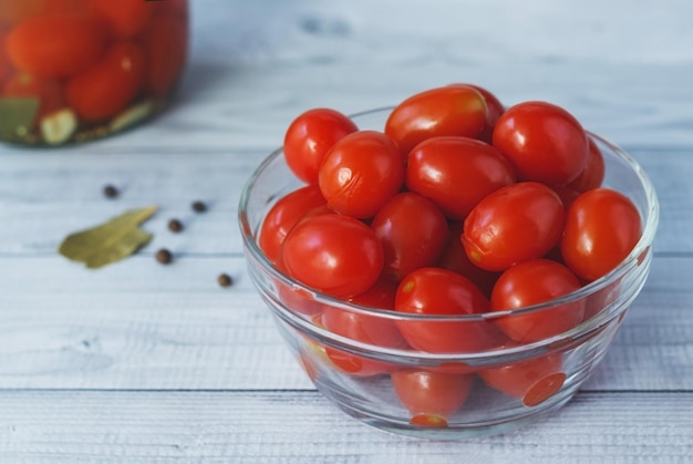 Tomate cereja em conserva em uma tigela de vidro com especiarias