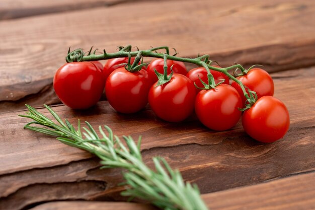 Tomate cereja em um fundo de madeira Ramo de tomate fresco Comida vegetariana