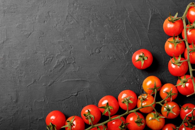 Tomate cereja em um fundo preto, vista superior.