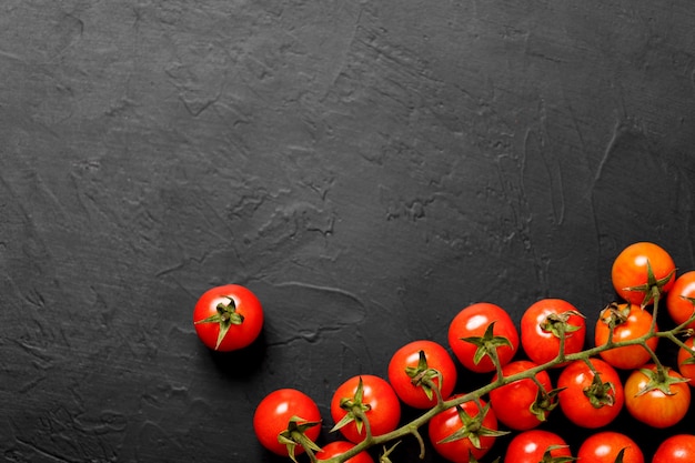 Tomate cereja em um fundo preto, vista superior.