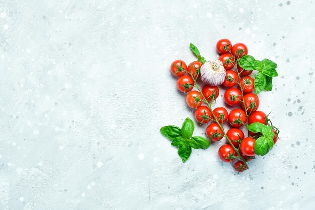 Tomate cereja em um galho em um fundo de pedra cinza Vista superior Espaço livre para texto