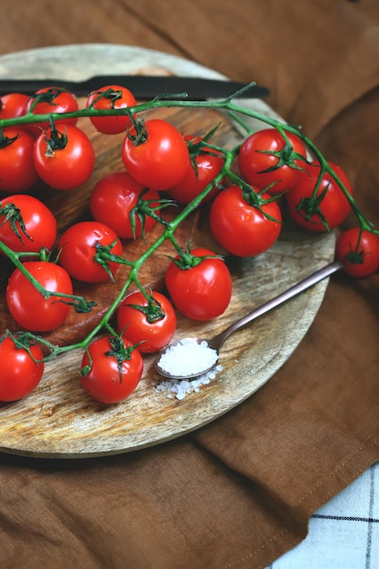 Tomate cereja em um galho em uma bandeja de madeira