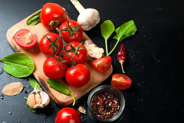 Tomate cereja em um galho, folhas de espinafre e especiarias