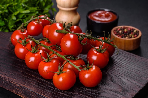 Tomate cereja fresco em um fundo preto com especiarias