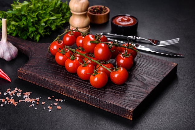 Tomate cereja fresco em um fundo preto com especiarias