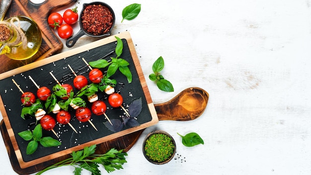 Tomate cereja, mussarela e manjericão. petiscos italianos. caprese vista superior. espaço livre para o seu texto.