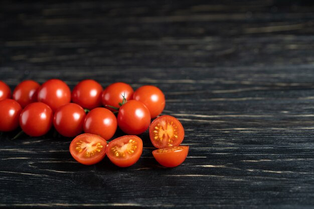 Tomate cereja na mesa de madeira preta escura