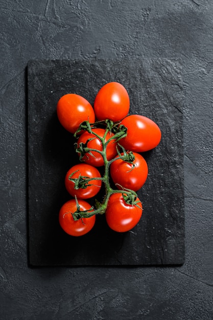 Tomate cereja vermelho no preto