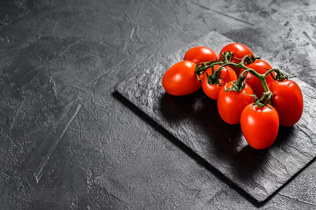 Tomate cereja vermelho no preto