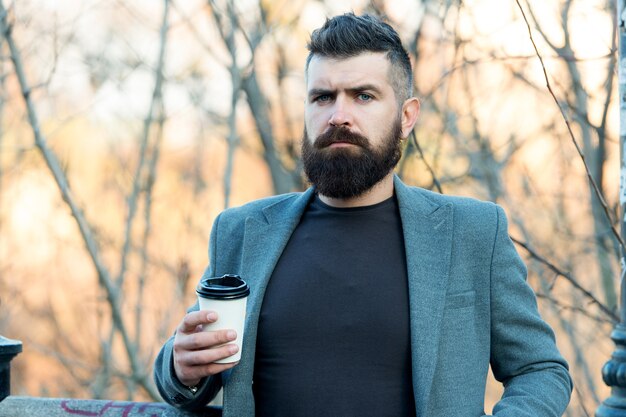 Tómate un descanso, bebe café. Hombre de negocios beber café durante el descanso laboral. Hipster brutal disfruta de la pausa para el café. Descanso. Mañana. Desayuno. Bebida y comida.