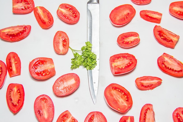 Tomate dividido en medio cuchillo de acero y hierbas frescas en el centro