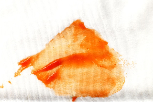 Foto tomate e mancha de ketchup em roupas de camisa branca fecham